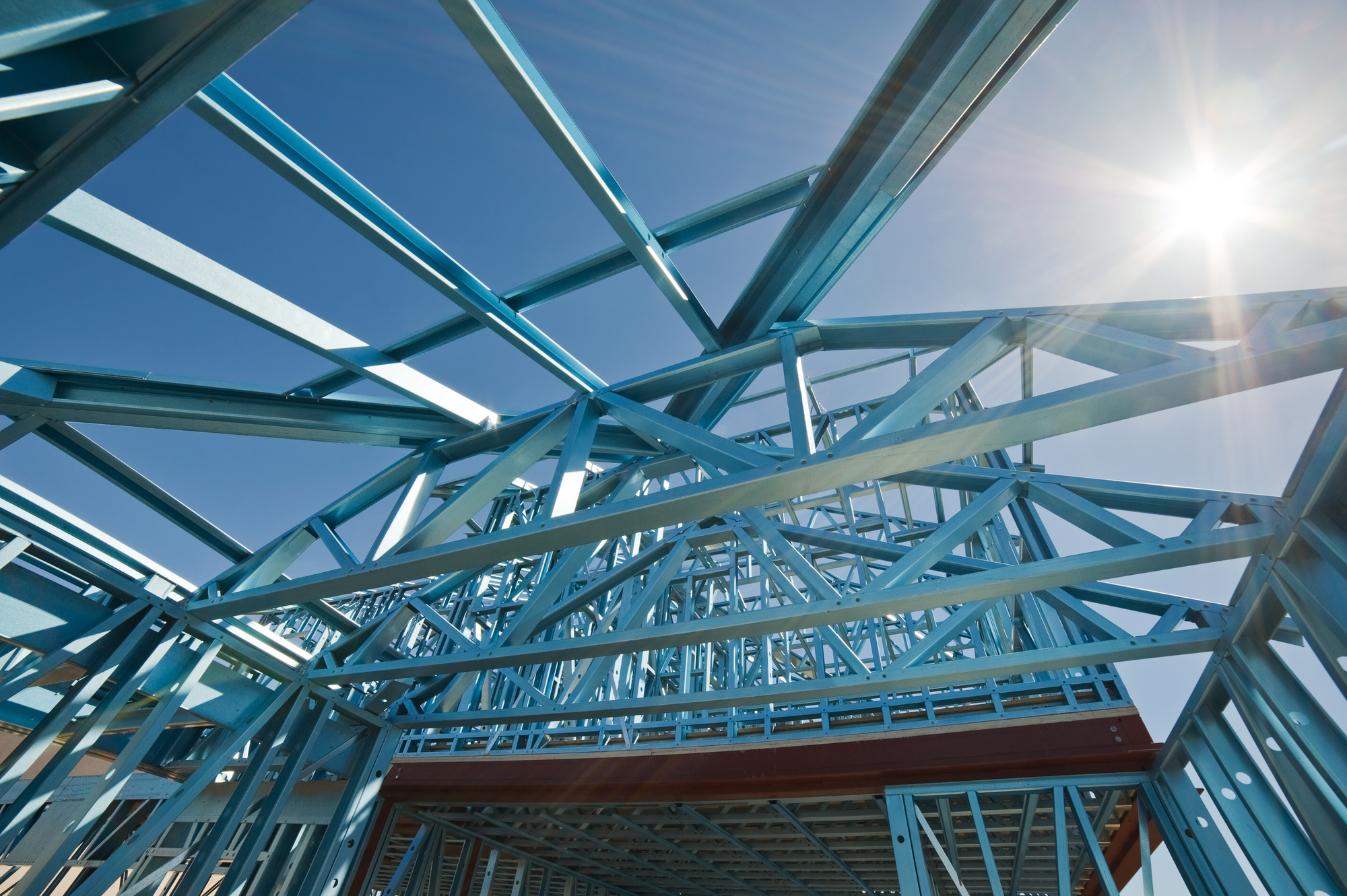 New residential construction home metal framing against a blue sky