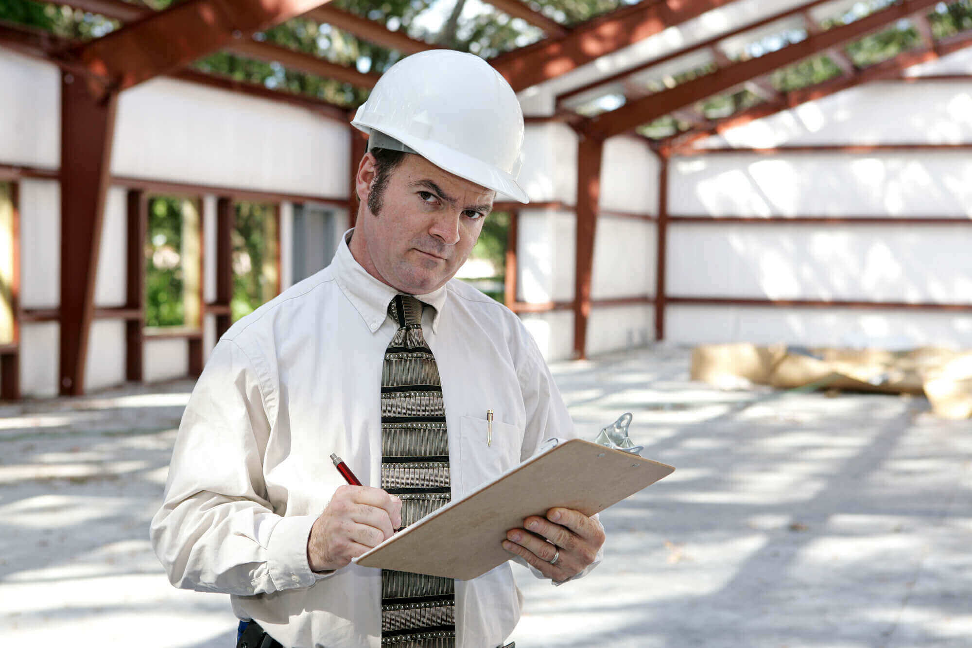 man-inspecting-steel-frame-building